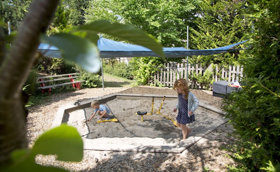 Kinder in der Sandkiste beim Kinderspielplatz Kinder in der Sandkiste beim Kinderspielplatz